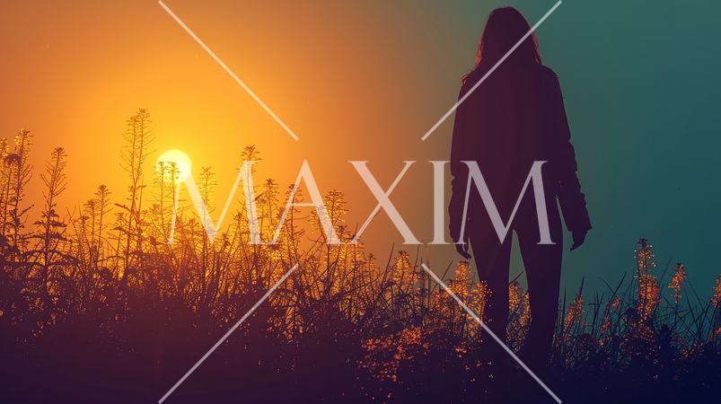 満開の菜の花畑から沈む夕日を眺めている一人の女性