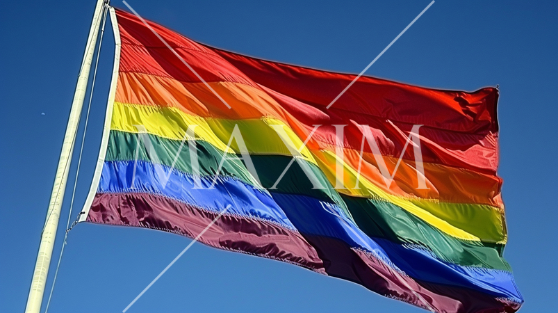 青い空に翻るLGBTを意識した虹色の旗